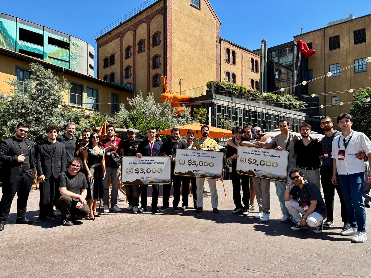 A group outdoors holding oversized prize cheques